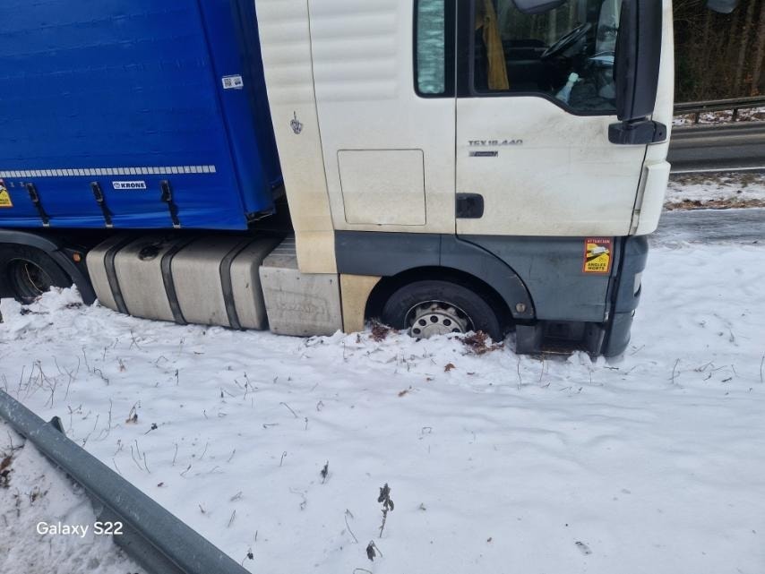 Holowanie pojazdów – co powinieneś wiedzieć przed drogowym wsparciem – LKW Help 24 Na zdjęciu widać ciężki holownik z rotatorem, który podnosi przód ciągnika siodłowego. Pojazd holujący jest wyposażony w żółte sygnały błyskowe, co zapewnia bezpieczeństwo uczestników ruchu drogowego podczas holowania.