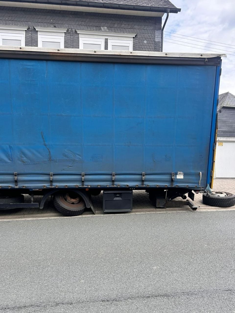 Шиномонтаж грузовиков LKW Help 24: синий шторный полуприцеп на обочине, запасное колесо при выездной замене колеса
