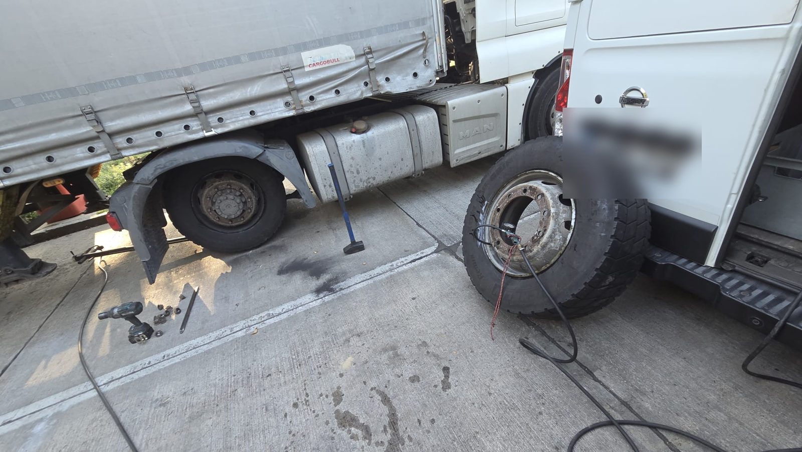 Mobilna wulkanizacja Niemcy: koło osi napędowej 315/70 R22.5 z manometrem i kluczem udarowym obok