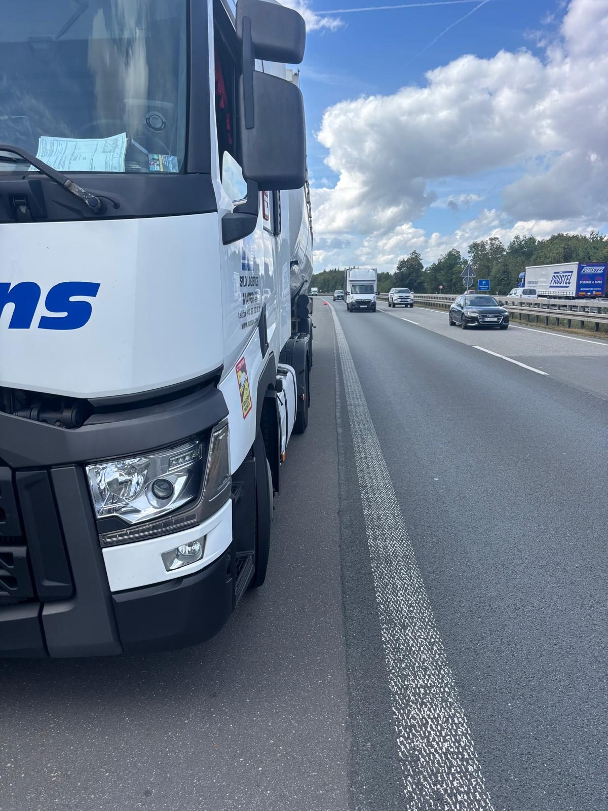 Ciągnik siodłowy z naczepą silosową na poboczu A3 koło Würzburga, serwis opon przy autostradzie w dzień